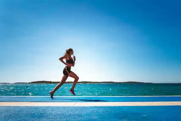 Woman running showing strong leg muscle Christchurch